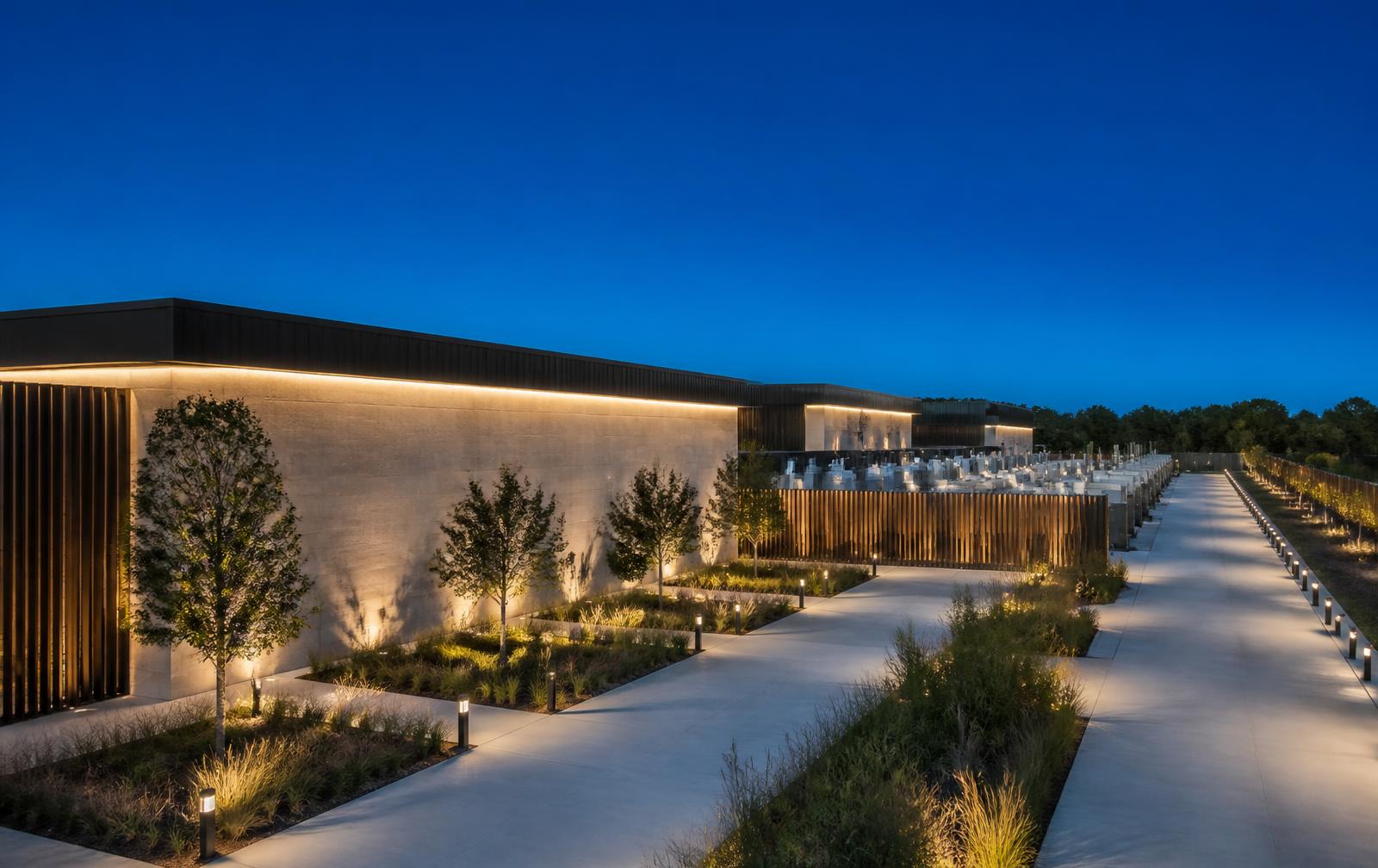 Data center campus at blue hour with illuminated walkways, landscaped grounds and adjacent energy infrastructure — a representative scene, not a GRIDSTROM customer site.